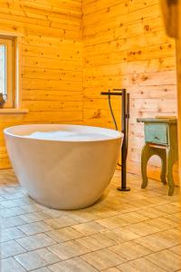 uma grande banheira num quarto com uma parede de madeira em Jup - a luxury boutique chalet em Warth