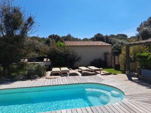 a swimming pool in a yard with a wooden deck at Songes d’été in Bonifacio