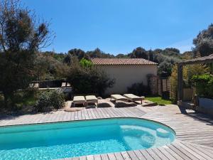 una piscina en un patio con terraza de madera en Songes d’été en Bonifacio