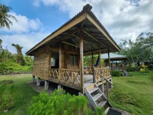 a small wooden house with a porch at MB Palambak Island Resort Pulau Banyak Aceh Singkil in Pulau Palambakbesar