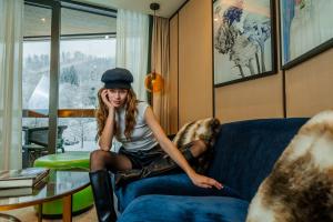 a girl sitting on a couch in a room at FIVE Zurich - Luxury City Resort in Zürich