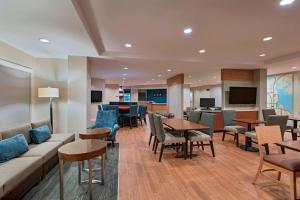 a hotel lobby with a couch and tables and chairs at TownePlace Suites by Marriott Lakeland in Lakeland