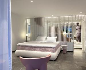 a bedroom with a bed and two pink chairs at Thomais Boutique Hotel in Nikiana