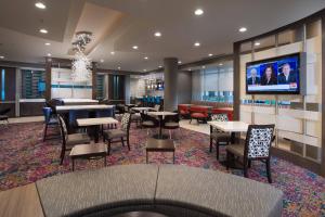 SpringHill Suites by Marriott Houston Hwy. 290/NW Cypress في هيوستن: مطعم بطاولات وكراسي وتلفزيون بشاشة مسطحة