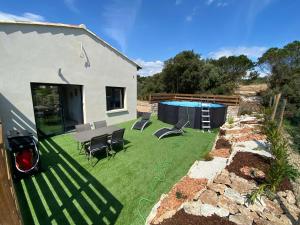 um quintal com piscina e cadeiras e uma casa em Villa Pacienta em Bonifacio