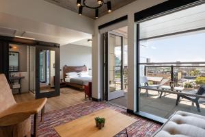 una sala de estar con cama y una habitación con puertas correderas de cristal en Moxy Minneapolis Downtown en Minneápolis