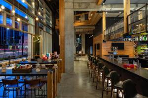 ein Restaurant mit Tischen und Stühlen und eine Bar in der Unterkunft Moxy Minneapolis Downtown in Minneapolis