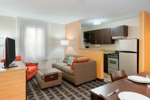a living room with a couch and a kitchen at TownePlace Suites Savannah Midtown in Savannah