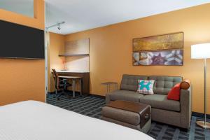 a hotel room with a bed and a couch and a desk at TownePlace Suites Savannah Midtown in Savannah