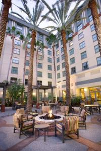 a hotel courtyard with palm trees and a fire pit at Residence Inn Irvine John Wayne Airport Orange County in Irvine