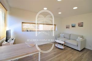 salon ze stołem i kanapą w obiekcie Le Berriau-Studio-CLiM/PK/WiFi/Plage Privée/Hyères w Hyères