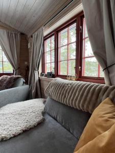 a bedroom with windows and a couch and a rug at Bromlebu in Notodden