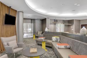 a hotel lobby with couches and tables and a tv at SpringHill Suites by Marriott Sacramento Natomas in Sacramento