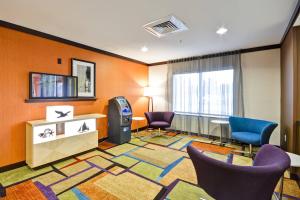 a hotel room with chairs and a slot machine at Fairfield Inn & Suites Tampa Fairgrounds/Casino in Tampa