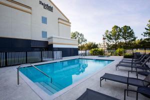 a swimming pool at a hotel with chairs around it at Fairfield Inn & Suites Tampa Fairgrounds/Casino in Tampa