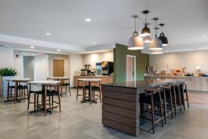 Fairfield Inn & Suites Savannah Airport في سافانا: مطبخ مع طاولات وكراسي في الغرفة
