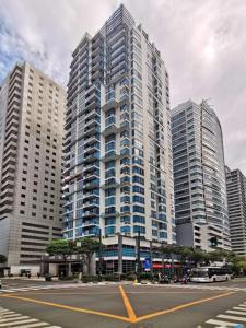 una calle de la ciudad con edificios altos en el fondo en The Pearl Interior Designed 1 BR Unit Burgos Circle BGC, en Manila