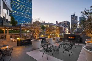 een dakterras met tafels en stoelen en een skyline van de stad bij Sheraton Melbourne Hotel in Melbourne