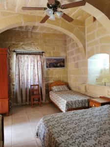 a bedroom with two beds and a ceiling fan at Bed and breakfast "Selena" with swim pool in Nadur