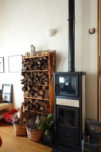 a fireplace with a television and a pile of logs at -MORC-beds & rooms-(home sharing)- in Pontevedra