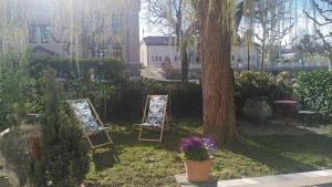 ジュネーヴにあるホテル デス ホルロガースの木の横の芝生に座る二頭のイーゼル