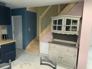 a kitchen with a staircase with a white cabinet and a table at Villa piscine/spa privé intérieur 33° ZOO DE LA FLECHE 24h DU MANS in La Flèche