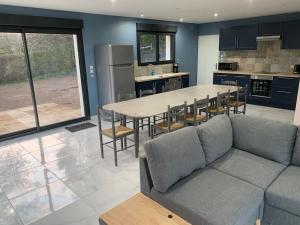 un soggiorno con un divano e un tavolo di Villa piscine/spa privé intérieur 33° ZOO DE LA FLECHE 24h DU MANS a La Flèche
