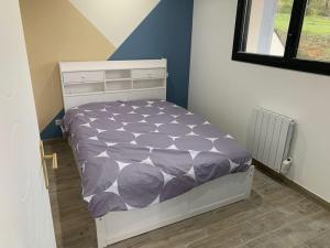 una camera da letto con un letto con un piumone viola di Villa piscine/spa privé intérieur 33° ZOO DE LA FLECHE 24h DU MANS a La Flèche Altre 46 foto