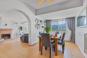 - un salon avec une table, des chaises et une cheminée dans l'établissement Monda Heights close to Marbella, à Monda