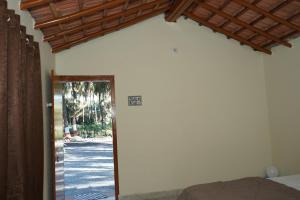 Habitación con una puerta que conduce a un dormitorio con porche. en Dwarkesh Farm&Resort, en Somnath