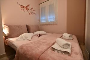 a bedroom with a bed with towels on it at Cozy Apartment Νear Nea Paralia of Thessaloniki in Thessaloniki