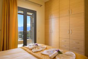 a bedroom with a bed with towels and a window at Elounda Blue Waves Residence in Elounda