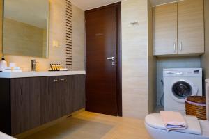 Elounda Blue Waves Residence في إيلوندا: حمام مع مرحاض ومغسلة وغسالة