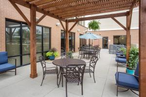 d'une terrasse avec des tables, des chaises et des fenêtres. dans l'établissement SpringHill Suites Louisville Downtown, à Louisville