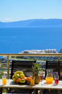 une table avec des fruits sur elle avec un train en arrière-plan dans l'établissement Elounda Blue Waves Residence, à Elounda