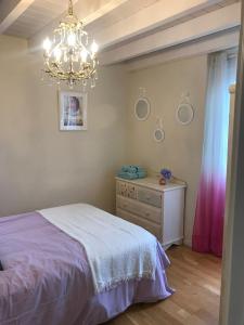 a bedroom with a bed and a dresser and a chandelier at VILLA OLIMAR 