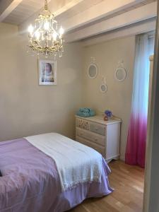a bedroom with a bed and a dresser and a chandelier at VILLA OLIMAR in San Juan de Prendones