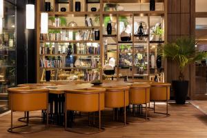 a restaurant with a bar with stools and books at Tunis Marriott Hotel in Tunis
