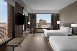 a hotel room with two beds and a large window at AC Hotel by Marriott San Antonio Riverwalk in San Antonio