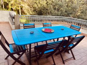 een blauwe tafel met stoelen en een bord watermeloen bij Villa Tanya in Trebbiantico