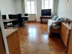 een woonkamer met een bank en stoelen en een televisie bij Rote Apfel in Pfreimd