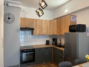 cocina con armarios de madera y nevera en Apartament Marko, en Zator