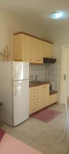 a kitchen with a white refrigerator and wooden cabinets at Smell Sea in Paralia Katerinis