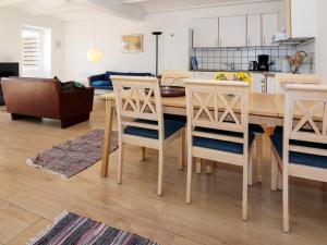 kuchnia i salon z drewnianym stołem i krzesłami w obiekcie Holiday home Storvorde XXII w mieście Storvorde