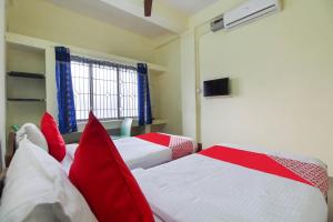 2 Betten in einem Zimmer mit roten Kissen in der Unterkunft OYO Royal Residency in Sūramangalam