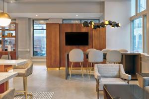 a living room with a table and chairs and a tv at Le Méridien St. Louis Downtown in Saint Louis