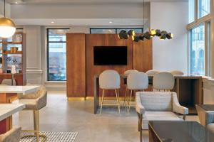 Una sala de estar con una mesa y sillas y un televisor. en Le Méridien St. Louis Downtown, en Saint Louis