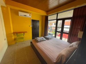 a bedroom with a bed with a window and a desk at Over the Moon hostel in Ban Houayxay