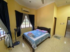 a bedroom with a bed and a window at Idaman homestay in Bukit Mertajam +2 photos