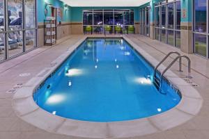 a swimming pool with blue water in a building at SpringHill Suites by Marriott Tulsa at Tulsa Hills in Tulsa